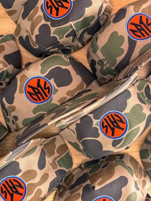 Camouflage caps embroidered with round orange and blue monograms