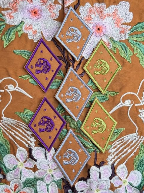 Diamond-shaped embroidered patches arranged over a floral embroidered garment